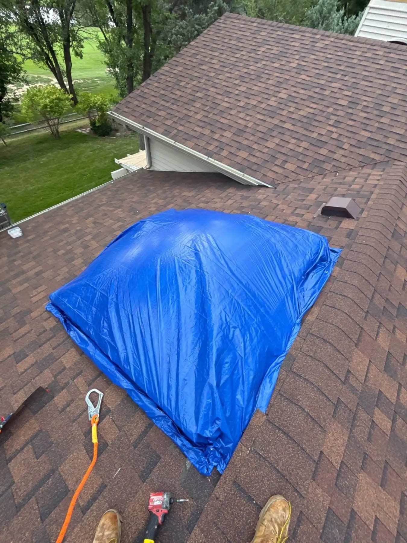 Blue tarp fastened over a section of shingled roof