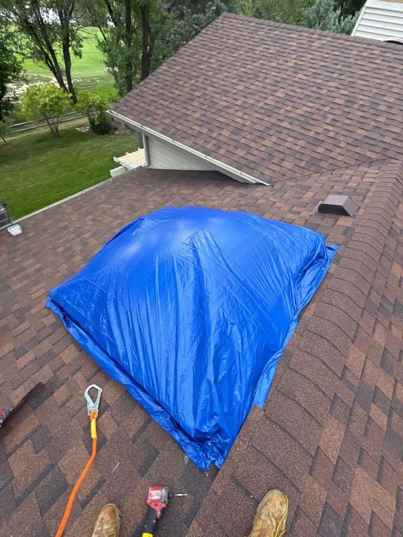 Blue tarp fastened over a section of shingled roof