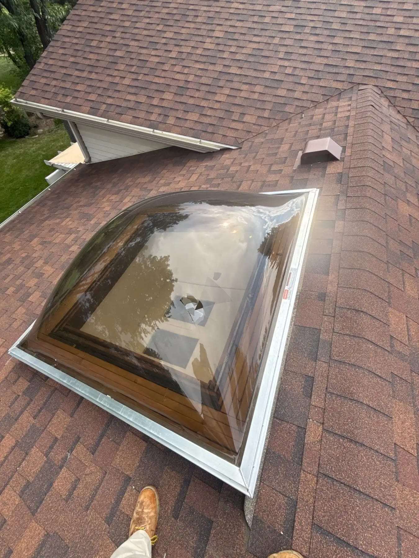Shingled roof with a dome skylight seen from the roof